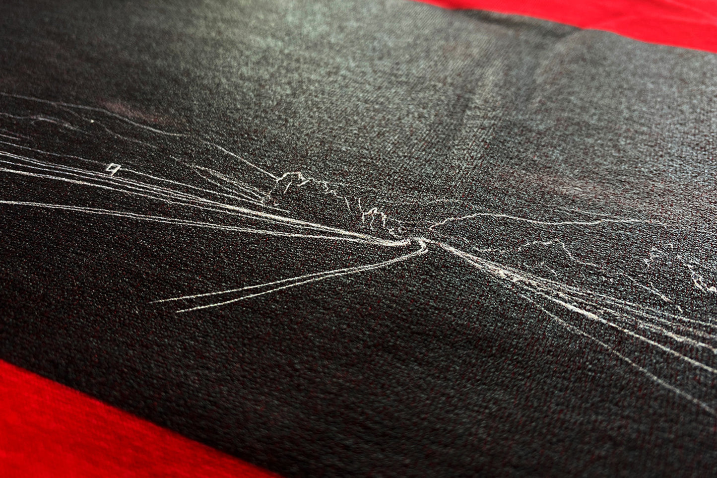 close up of red T-Shirt featuring a stunning vector art graphic inspired by a scenic drive through mountains and trees in Sicily